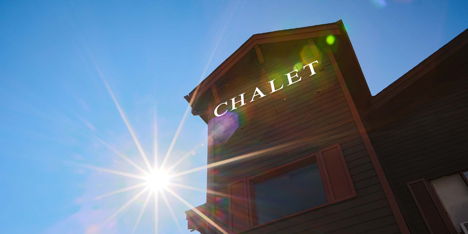 Radium Chalet building sign against a blue sky